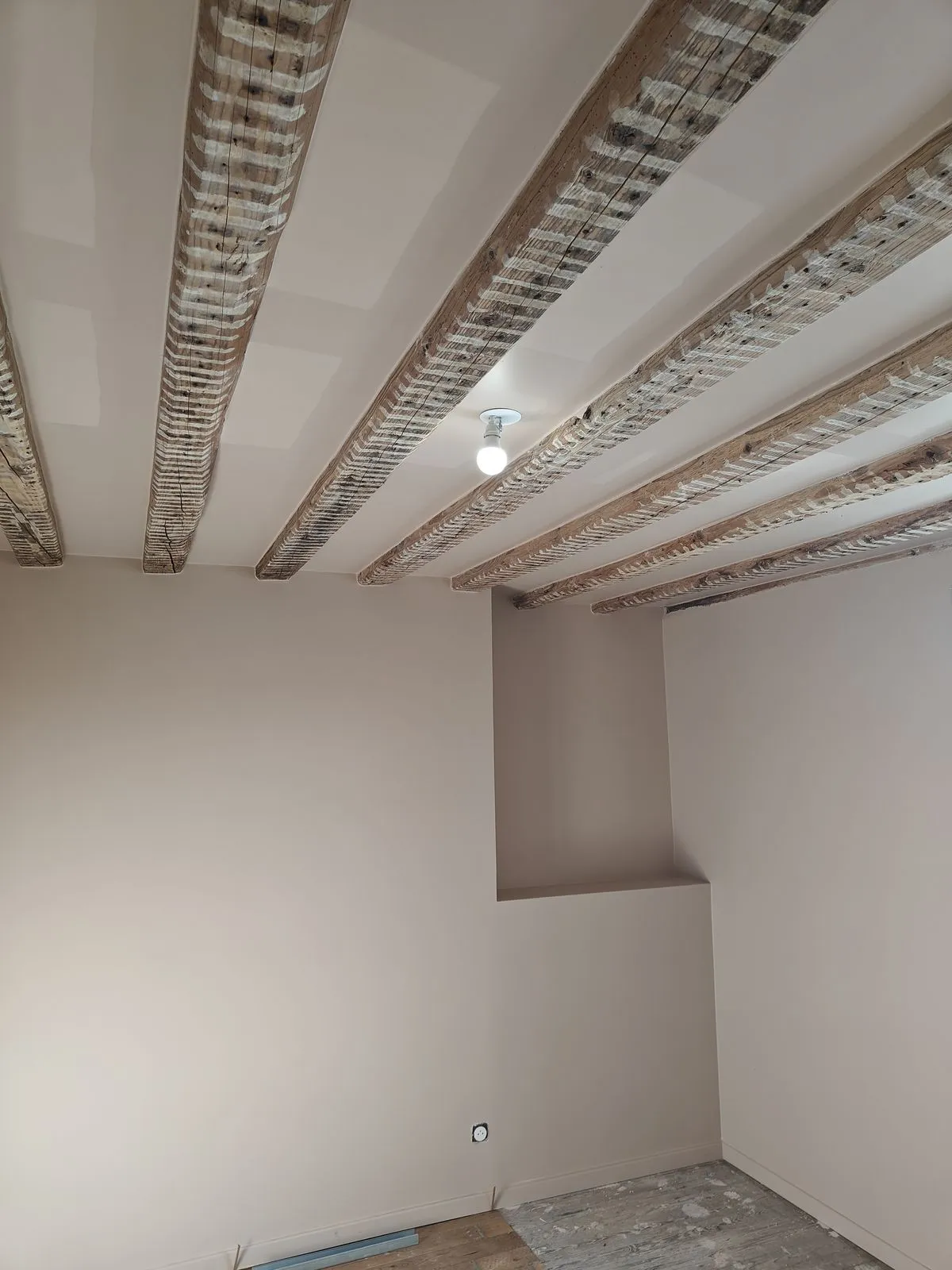 La chambre en fin de chantier : murs et plafond repris, solives apparentes