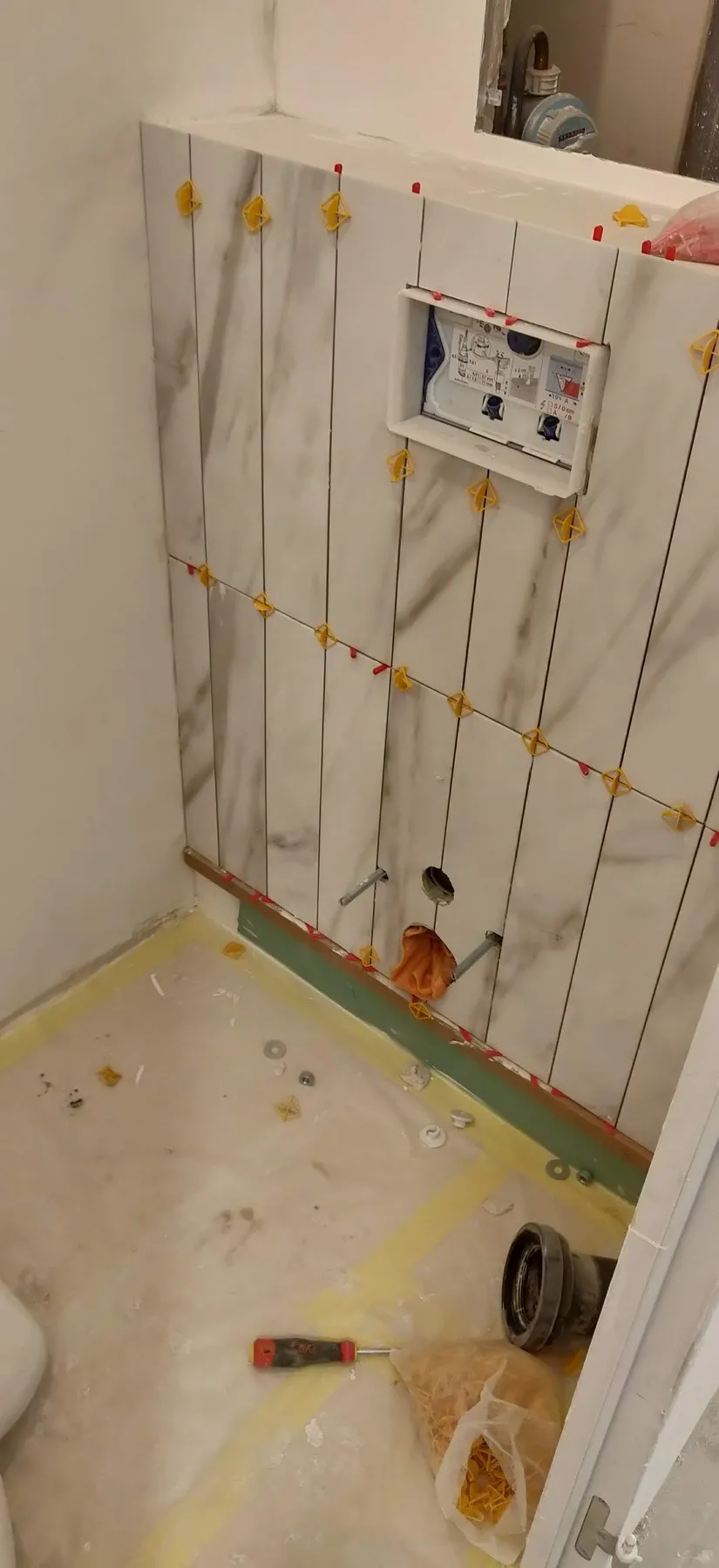 Le bâti des toilettes suspendues et la faïence en cours de pose