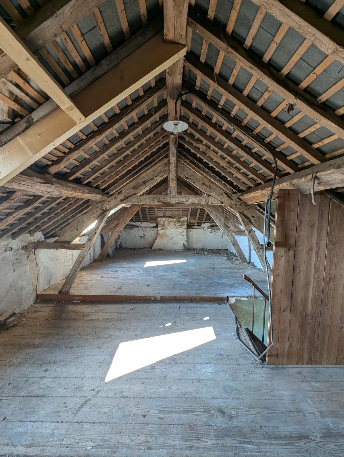 Le grenier avant travaux : charpente et voliges apparentes, plancher brut