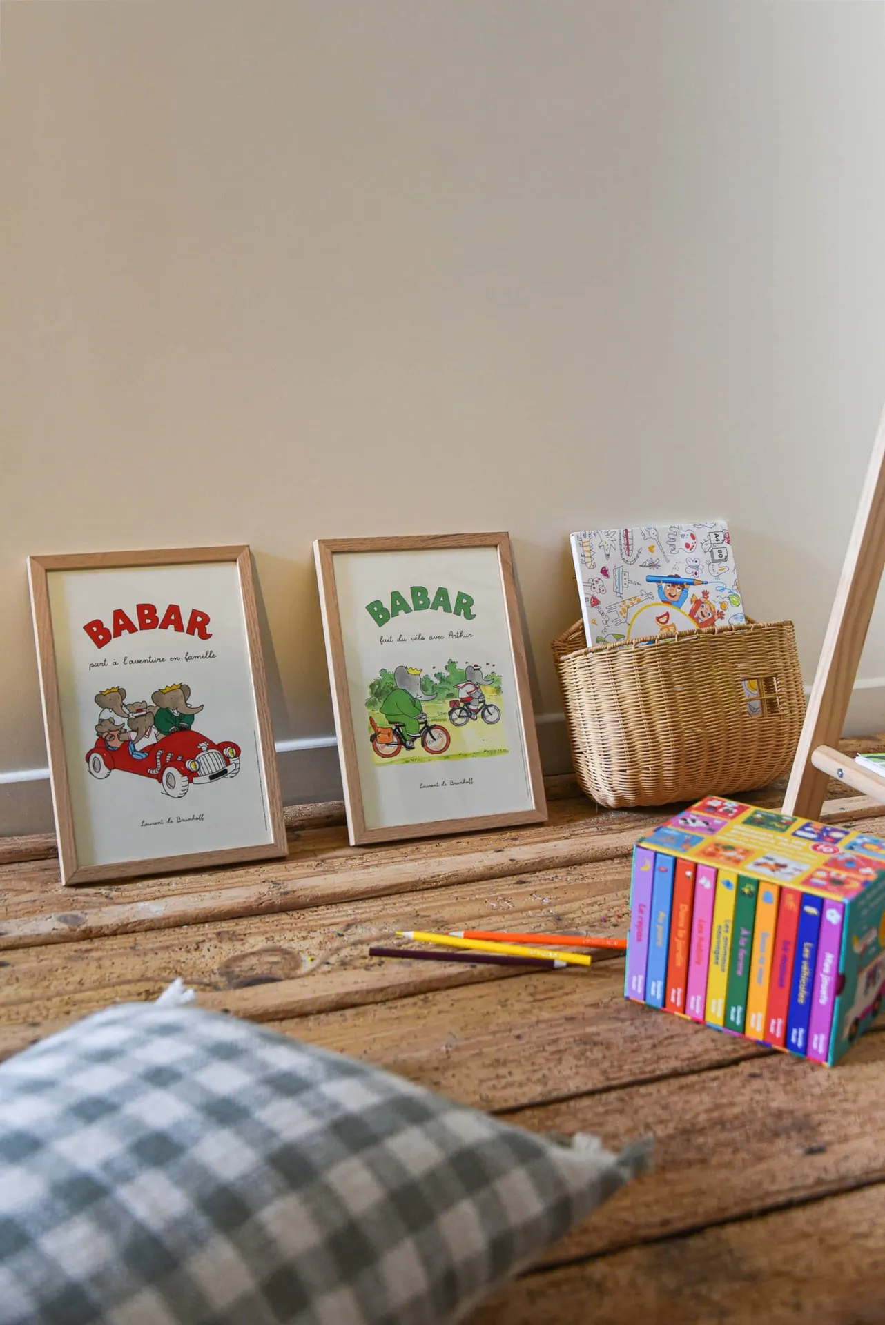 Un coin de l'espace des enfants : livres, affiches et coussin sur le plancher ancien