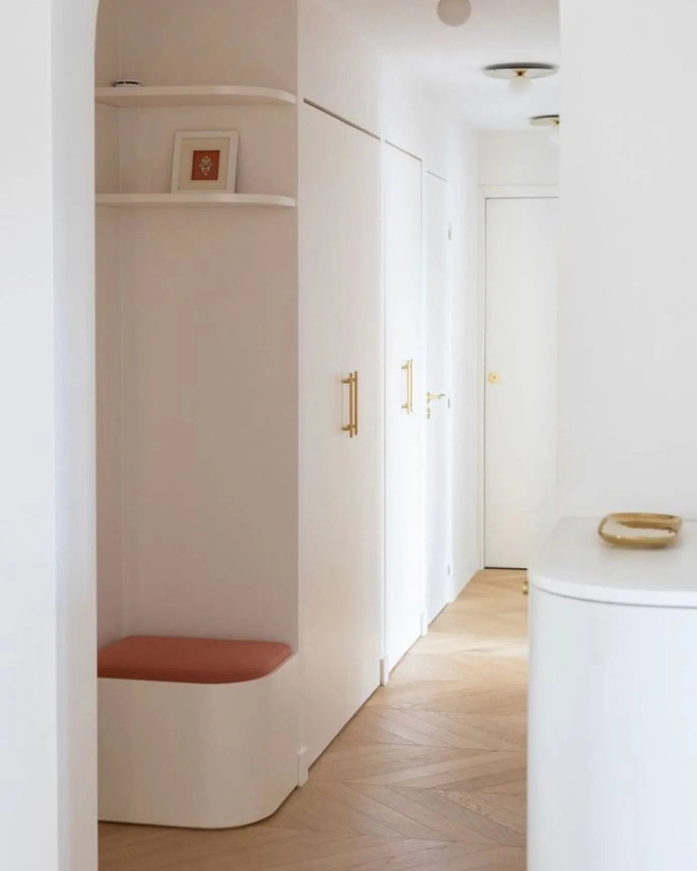 L'entrée et le couloir terminés : arche, banquette en niche, placards sur mesure et parquet à chevrons