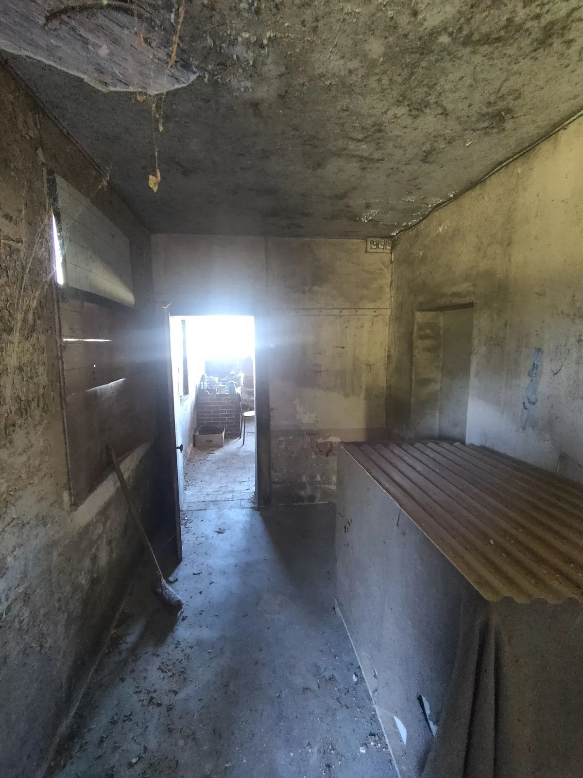 L'ancienne cuisine avant travaux : pièce étroite et sombre, murs et plafond dégradés
