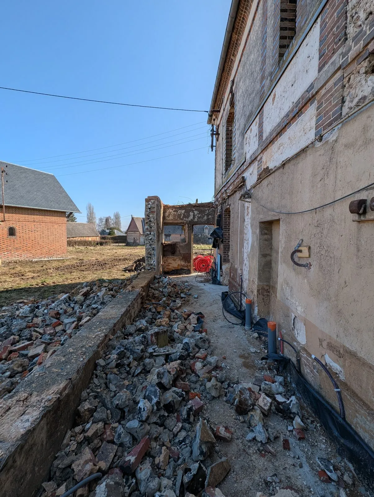 Les gravats de l'ancienne cuisine démolie, le long de la façade