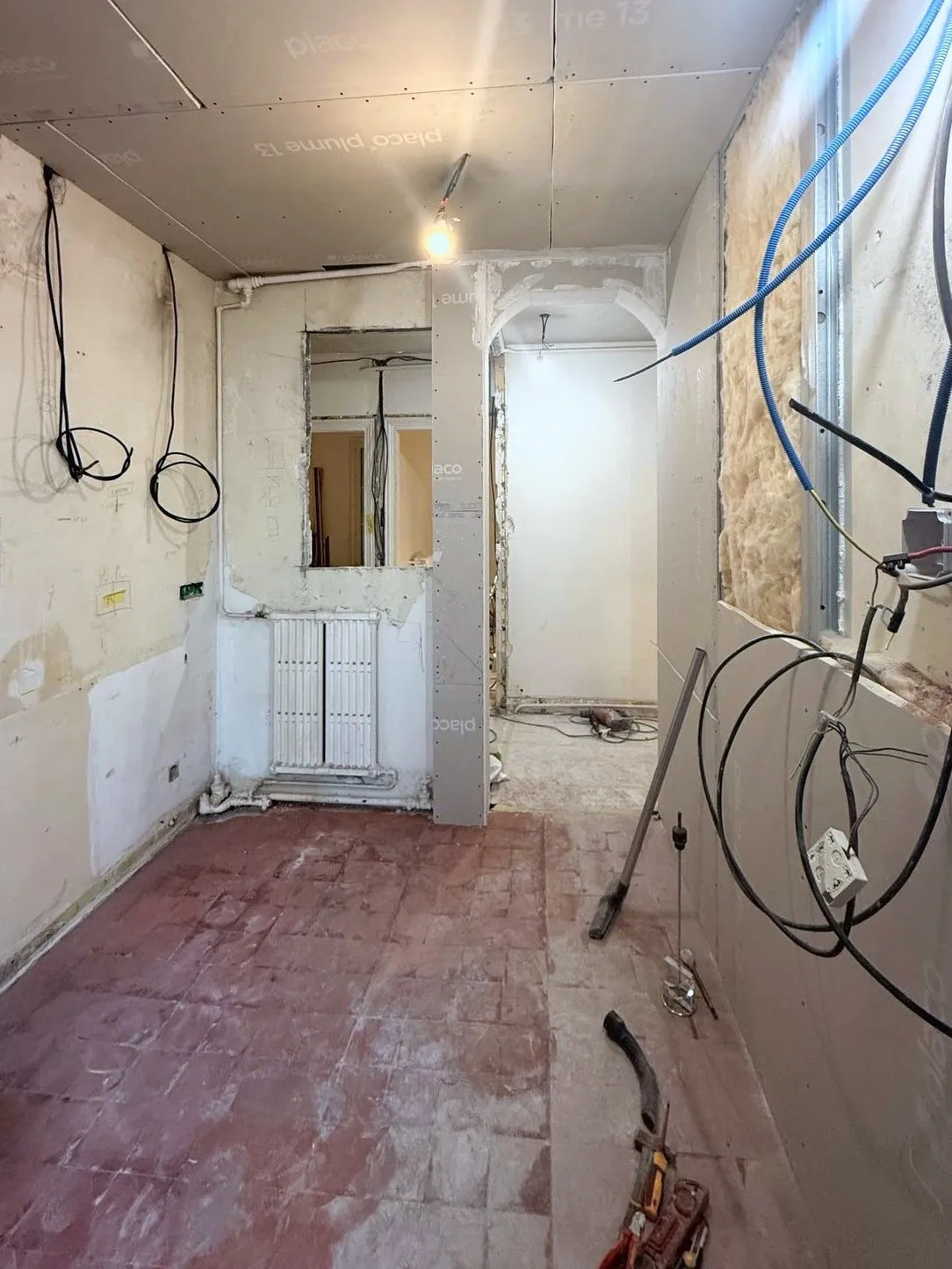 La cuisine pendant le chantier : murs à nu, gaines électriques et alimentations en attente