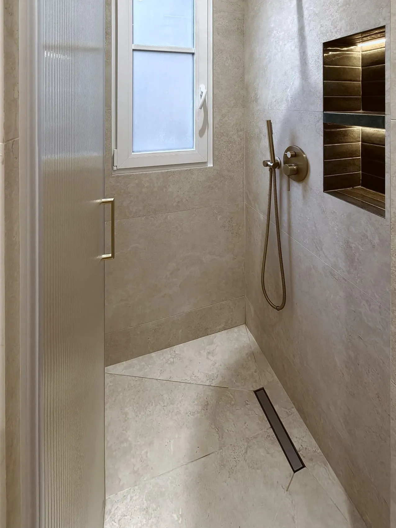 Douche à l'italienne avec niche éclairée et robinetterie en laiton