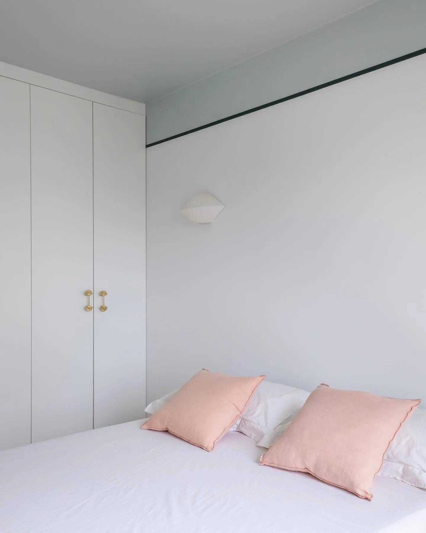 La seconde chambre terminée : placards toute hauteur, murs clairs, applique au-dessus du lit