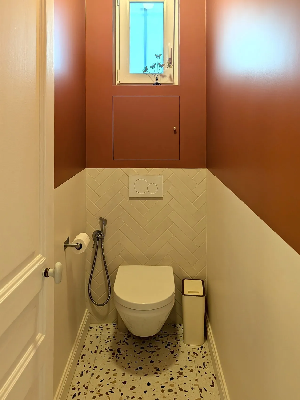Les toilettes terminées : WC suspendu, murs terracotta et sol en terrazzo